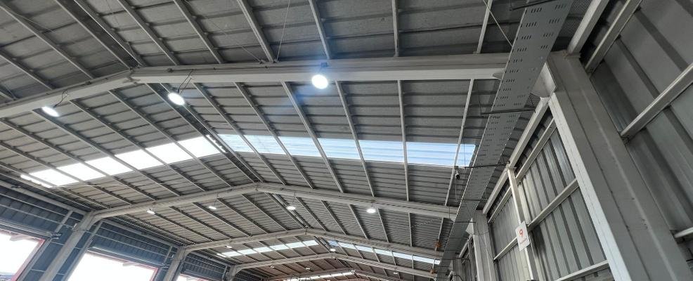 Techumbre de nave industrial con luminarias LED de alta potencia instaladas y lucernarios.